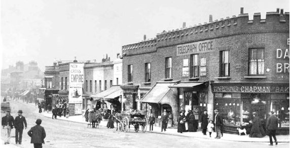 Chapman Bakers, on the corner of
Griffin Road and Plumstead High Street, tel:
WOO 0388 Orchard Street is the next street
on the right, just past the 'New Cross
Empire' poster and in front of the Rose and
Crown public house, which is the last of the
darker buildings, with a large lamp in
front. Photo: Helen Jones via John Boons web
site.